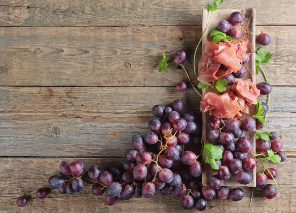 Jamon serrano with parsley and grape. — Stock Photo, Image