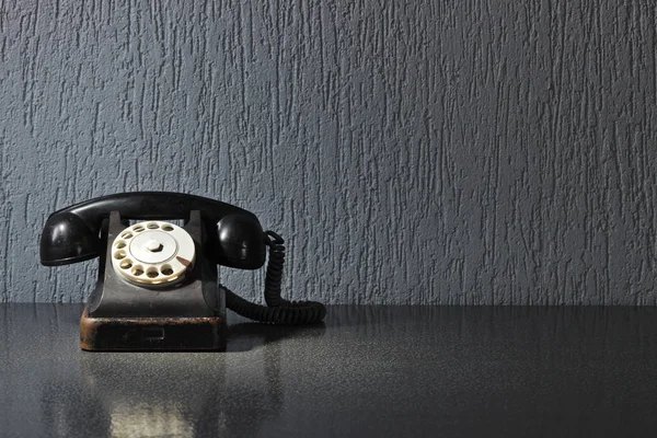 Starý černý telefon na šedý stůl. — Stock fotografie