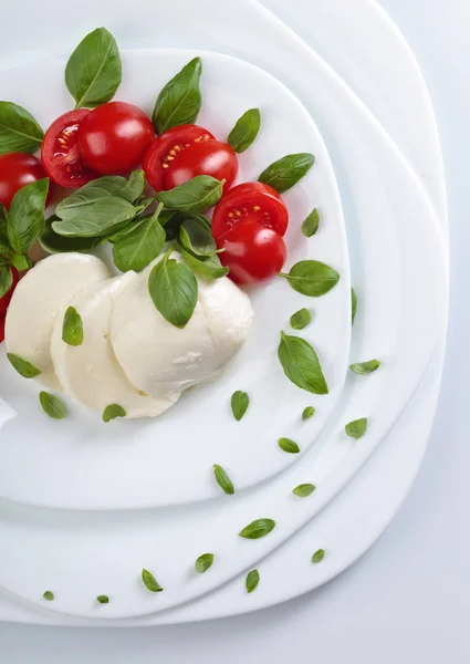 Mozzarella with tomato and green basil. — Stock Photo, Image