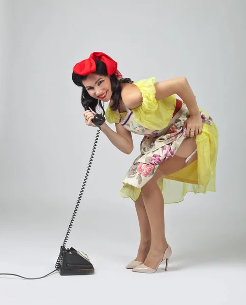 Hermosa mujer en estilo pin up con teléfono vintage . — Foto de Stock