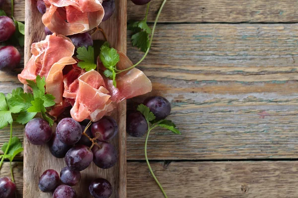 Jamon serrano with parsley and grape. — Stock Photo, Image