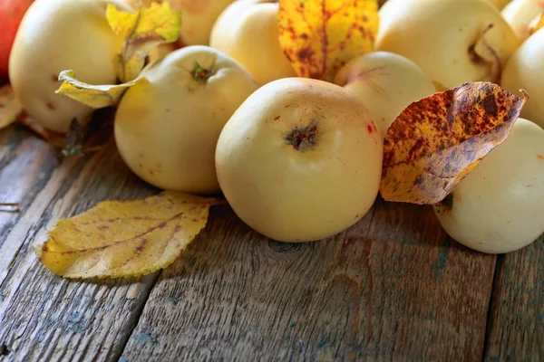 Apples with yellow leaves wooden table. — Stock Photo, Image