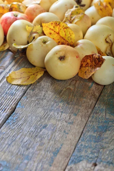 Apples with yellow leaves wooden table. — Stock Photo, Image