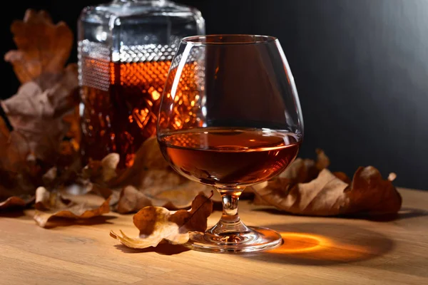 Brandy and dried up oak leaves . — Stock Photo, Image