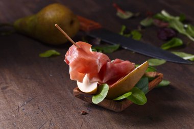 Prosciutto ile armut ahşap bir masa üzerinde