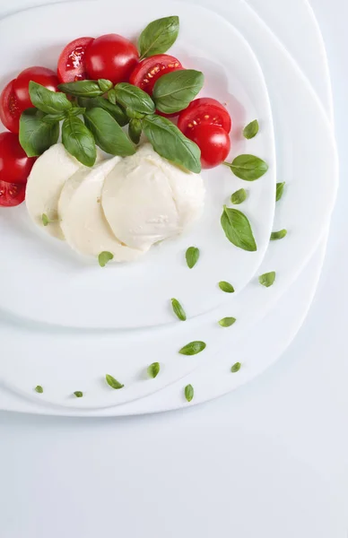 Mozzarella with tomato and green basil. — Stock Photo, Image