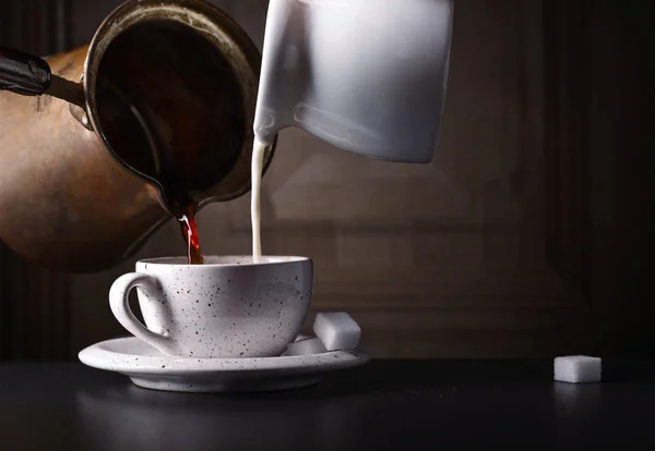 Taza de café con leche y azúcar en la mesa negra — Foto de Stock
