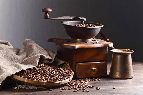 Macinino da caffè vecchio e chicchi di caffè tostati su tavolo di legno — Foto Stock