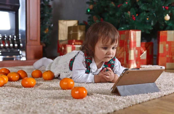 Маленькая девочка с табличкой в комнате с рождественскими украшениями — стоковое фото