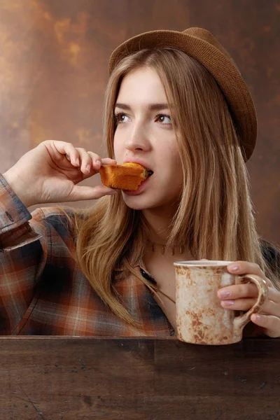 Woman with coffee and a cupcake. — Stock Photo, Image