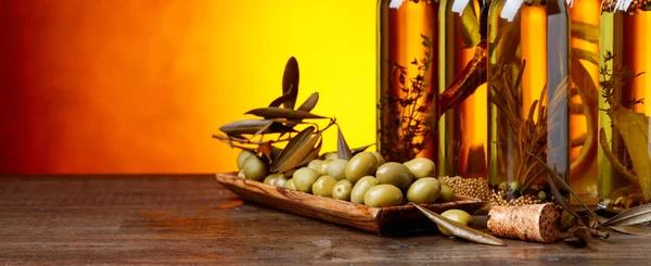 Aceitunas verdes y botellas de aceite de oliva  . — Foto de Stock