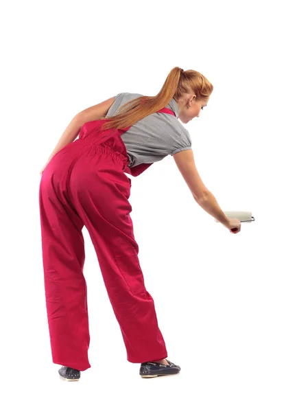 Young woman in red overalls with roller. — Stock Photo, Image
