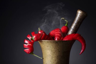 Eski bir pirinç harç içinde kırmızı biber biber .