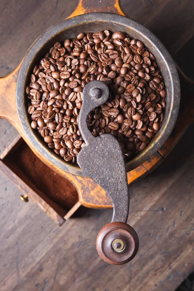 Primer plano de molinillo de café viejo y granos de café tostados — Foto de Stock