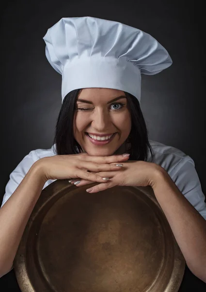 Ung kvinna med stor mässing pan. — Stockfoto
