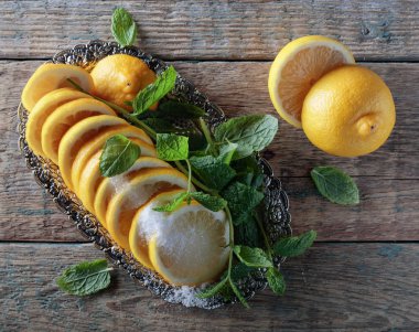 Şeker ve nane yaprakları ile limon dilimleri.