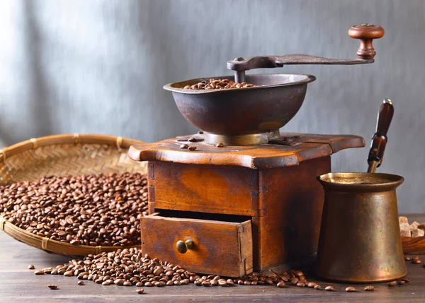Molinillo de café viejo y granos de café tostados en mesa de madera — Foto de Stock