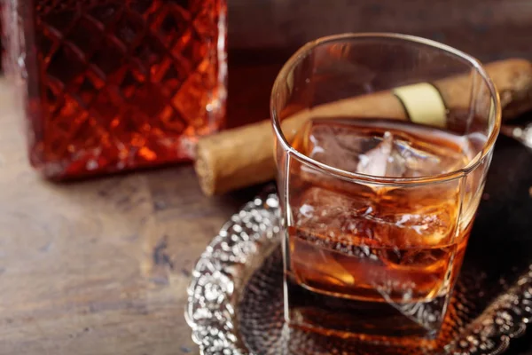 Pohár whisky és egy szivar a régi fából készült asztal. — Stock Fotó