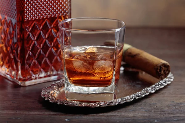 Vaso de whisky y cigarro sobre una vieja mesa de madera . —  Fotos de Stock