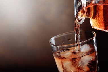 Viski bir sürahi bir cam içine dökülür .