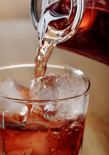 Whiskey is poured from a carafe into a glass .