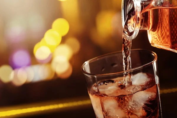 Il whisky viene versato da una caraffa in un bicchiere  . — Foto Stock