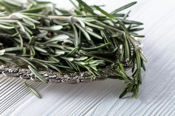 Rosemary on a white wooden table. — Stock Photo, Image