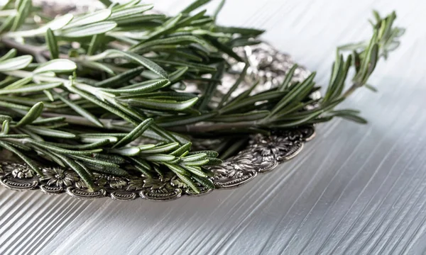 Rosemary on a white wooden table. — Stock Photo, Image