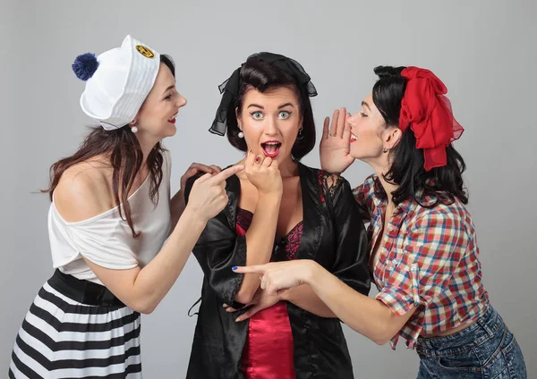 Три молоді жінки шепочуть плітки  . — стокове фото