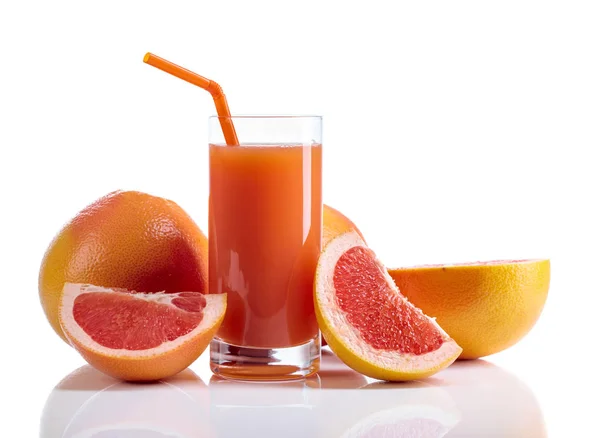 Sklenka čerstvé grapefruitové šťávy a řez ovoce bílým pozadím. — Stock fotografie