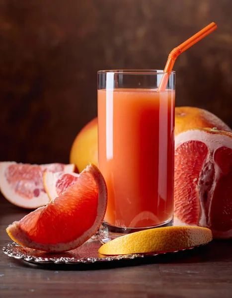 Glas frischer Grapefruitsaft und geschnittene Früchte . — Stockfoto