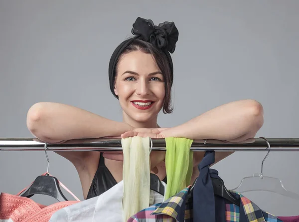 Mulher atraente de pé perto das prateleiras de roupas  . — Fotografia de Stock