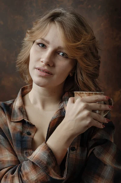 Νεαρή όμορφη γυναίκα στο καρό πουκάμισο με κούπα καφέ . — Φωτογραφία Αρχείου