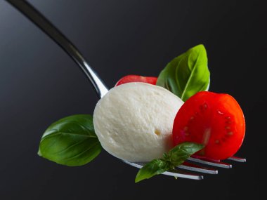  Kiraz domates ve yeşil Mozzarella peyniri çatal üzerinde fesleğen 