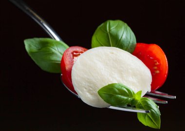  Kiraz domates ve yeşil Mozzarella peyniri çatal üzerinde fesleğen 