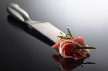  Siyah yansıtıcı arka planda biberiyeli jambon.. 