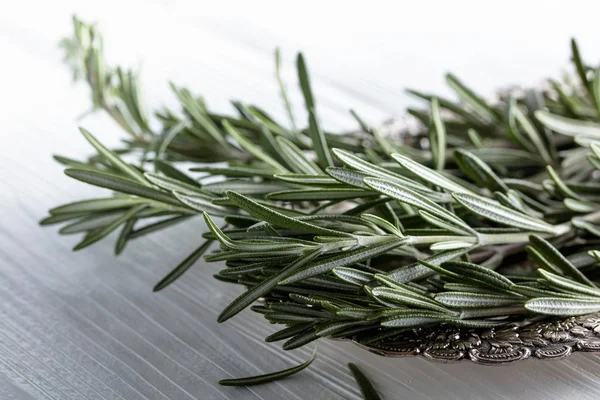 Rosemary on a white wooden table. — Stock Photo, Image