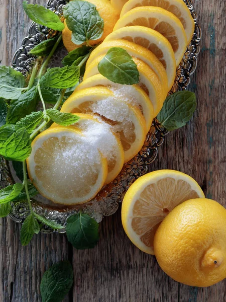 Лимонные ломтики с сахаром и мятными листьями . — стоковое фото