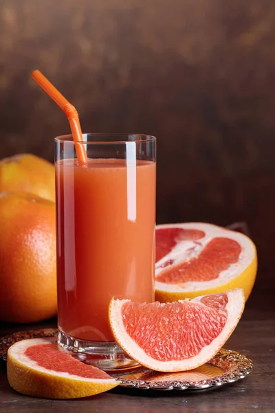 Sklenka čerstvé grapefruitové šťávy a řezu ovoce . — Stock fotografie