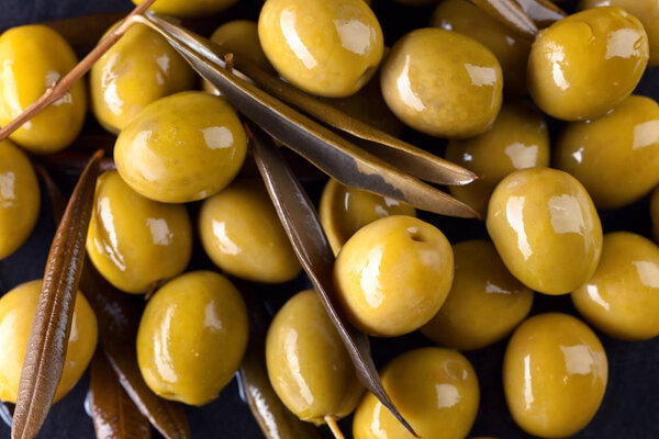 Green olives with leaves.