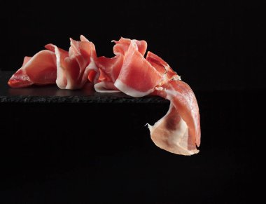  Prosciutto siyah bir zemin üzerine.