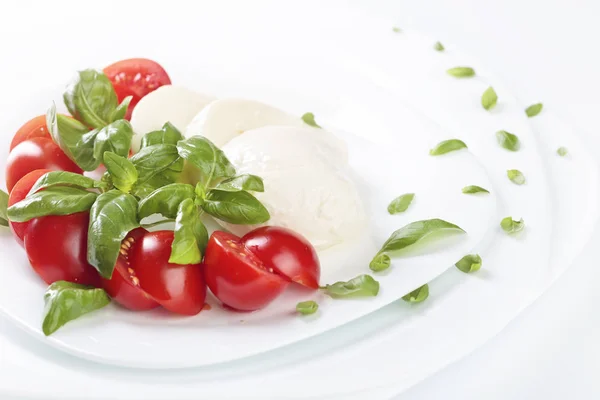 Mozzarella with tomato and green basil. — Stock Photo, Image