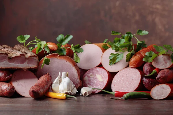 Different sausages and smoked meats on a  wooden table . — Stock Photo, Image