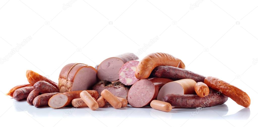 Different sausages and smoked meats isolated on white .