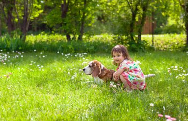 Küçük kız köpek çim ile oynarken .