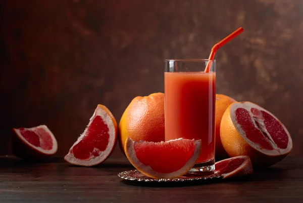 Glas frischer Grapefruitsaft und geschnittene Früchte . — Stockfoto