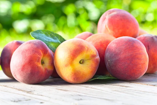 Saftiga persikor på träbord. — Stockfoto