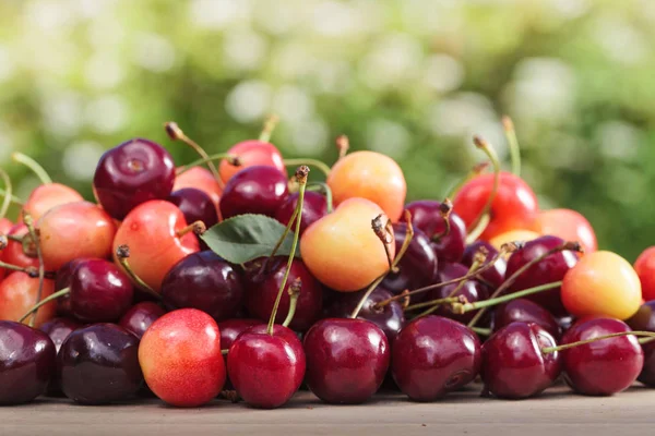 Juicy sweet cherries on wooden table. — Stock Photo, Image