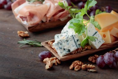 Çeşitli peynirler, üzüm ve prosciutto .
