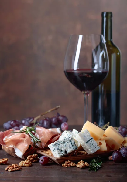 Copa de vino tinto con varios quesos, frutas y jamón  . — Foto de Stock